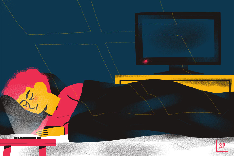 Eine Person mit rosa Haaren schläft friedlich im Bett unter einer schwarzen Decke und übt sich in guter Schlafhygiene. Ein Fernseher auf einem gelben Ständer und ein aufgeklappter Laptop stehen in der Nähe in dem sanft beleuchteten Raum.