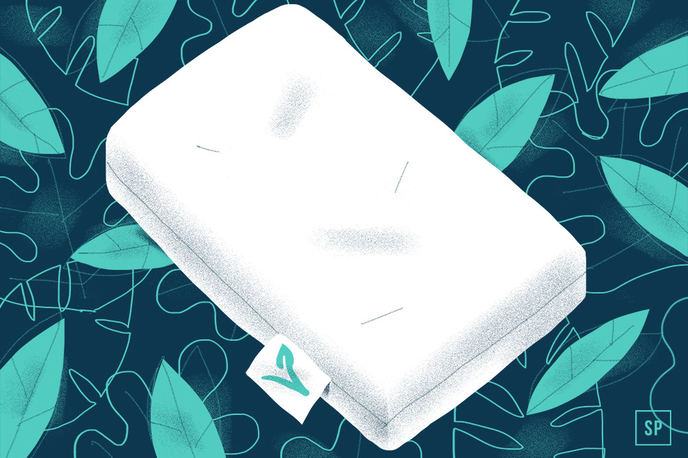 Eine weiße vegane Matratze mit einem grünen Blattanhänger ruht auf einem Hintergrund aus stilisierten blaugrünen und grünen Blättern, die ein von der Natur inspiriertes, umweltfreundliches Thema darstellen.