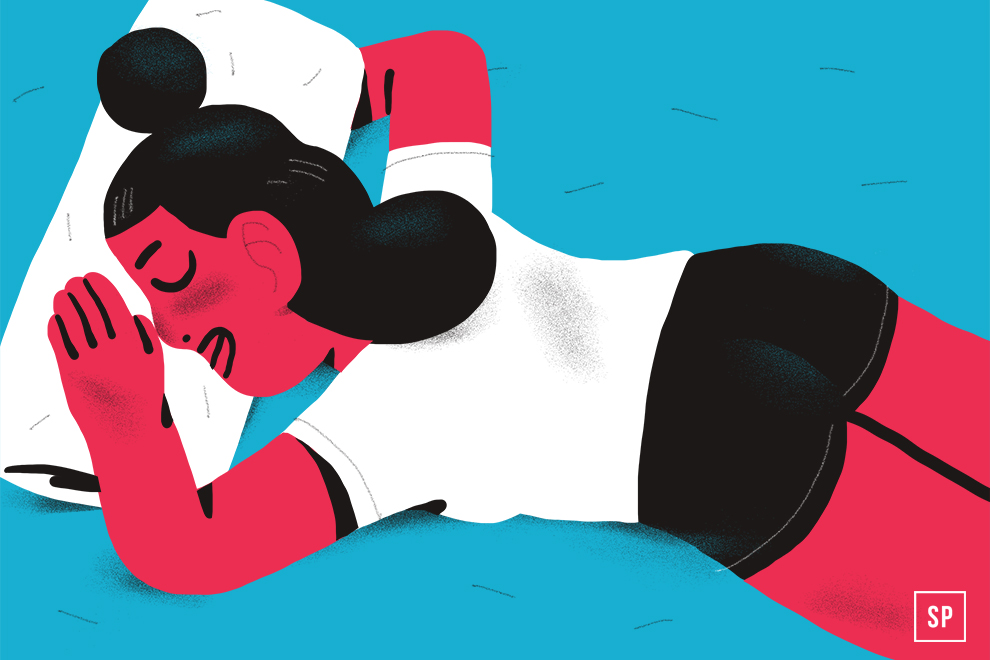 Illustration einer Person mit dunklen Haaren in einem Dutt auf der Seite liegend, schlafend mit einem Bauchschläferkissen. Sie trägt ein weißes Hemd und schwarze Shorts, die vor einem blauen Hintergrund stehen.