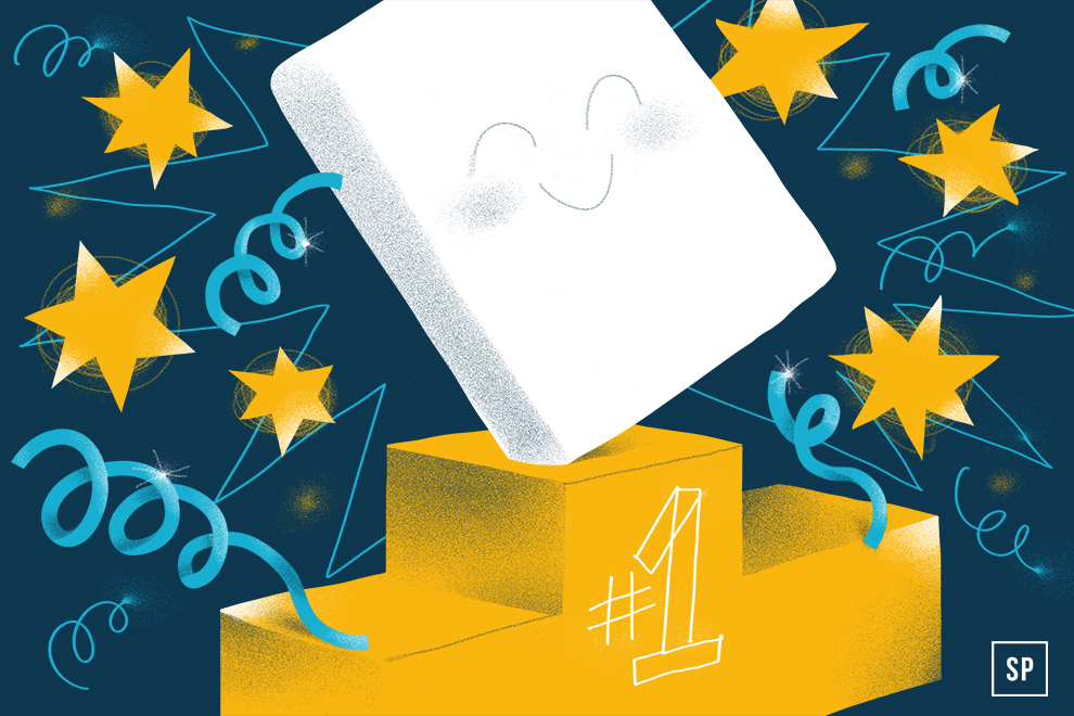 Ein lächelnder weißer Block steht auf einem goldenen Siegertreppchen mit der Aufschrift "#1" und feiert seine Auszeichnung als ntv Testsieger unter den Matratzen Online-Shops, umgeben von Sternen und Luftschlangen vor einem dunkelblauen Hintergrund.