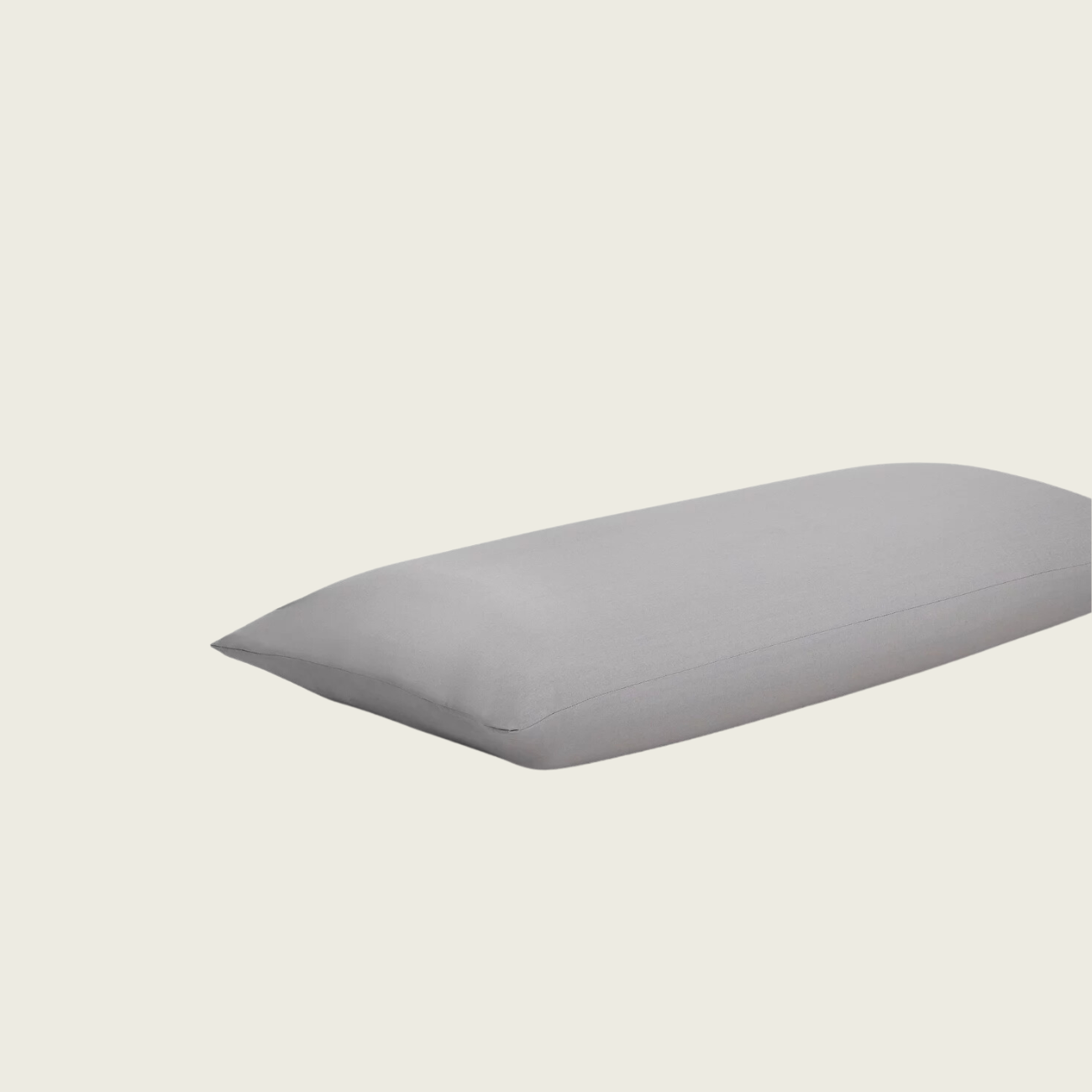 Ein einzelnes graues Kissen mit glatter, glatter Oberfläche ist vor einem hellen, gebrochen weißen Hintergrund zentriert.