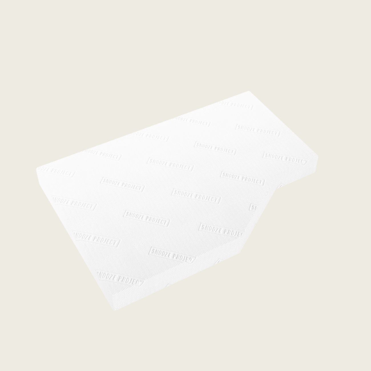 Eine rechteckige, weiße Matratzenauflage mit einem leicht schrägen Schnitt auf einer Seite, die vor einem schlichten, cremefarbenen Hintergrund abgebildet ist. Die Oberfläche weist ein dezentes, sich wiederholendes Muster mit schwachem Text auf.