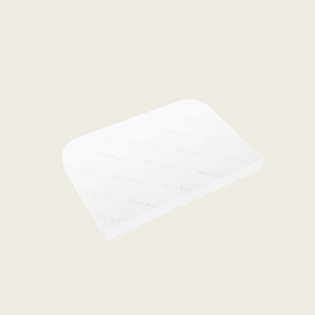 Ein einzelner rechteckiger weißer Baumwollblock mit abgerundeten Ecken, der einem LKW Matratze Mercedes Actros MP4 Big Space ähnelt, wird auf einem hellbeigen Hintergrund gezeigt. Der Block weist eine subtile Struktur mit schwach geprägtem Text auf seiner Oberfläche auf.