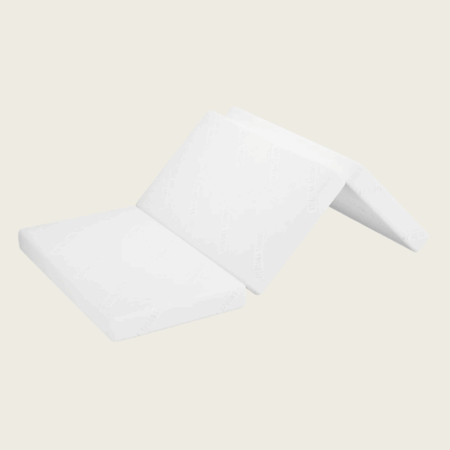 Eine weiße PKW-Matratze/Klappmatratze für den Skoda Octavia 4 wird auf hellem Hintergrund teilweise aufgefaltet gezeigt, wobei die drei miteinander verbundenen Schaumstoffteile sichtbar werden.