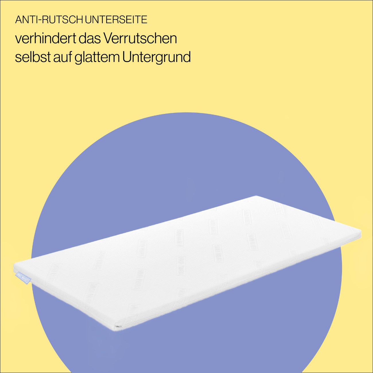Topper Anti-Rutsch Der rechteckige Topper nach Maß in Weiß liegt auf einer blauen Ovalform vor gelbem Hintergrund. Deutsche Aufschrift oben: Anti-Rutsch Unterseite verhindert das Verrutschen selbst auf glattem Untergrund.