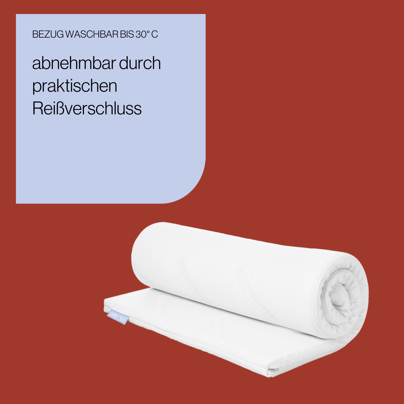Topper - Bezug Ein rechteckiger Topper nach Maß (weiß, gerollt, mit Etikett) liegt auf rotem Hintergrund. Text oben: Abnehmbar dank Reißverschluss, Bezug waschbar bis 30°C.