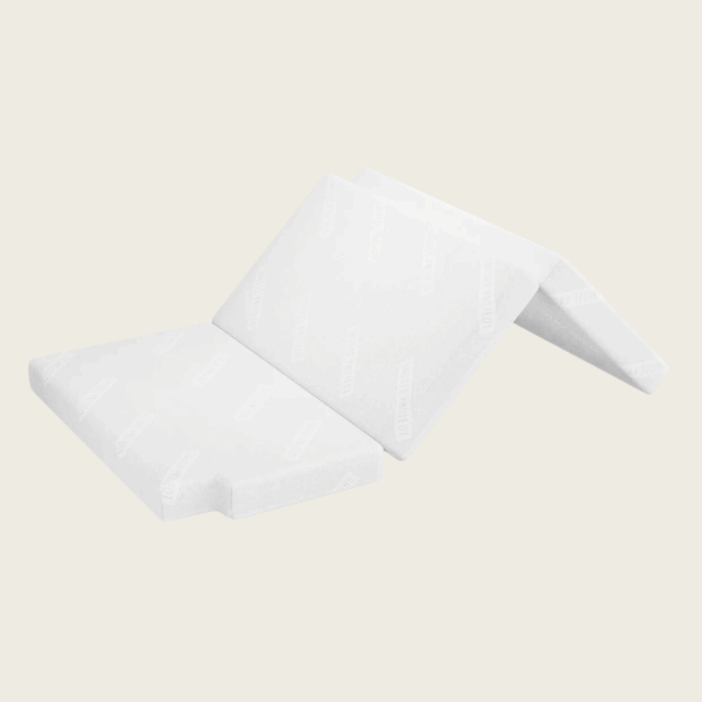 Eine weiße PKW Matratze/Klappmatratze VW T6/T6.1 California (Ocean/Coast) mit 2er Sitzbank (für unten) ist teilweise gefaltet auf einem einfarbigen Hintergrund abgebildet und zeigt ihren glatten Bezug mit dezenten Mustern. Ideal für Reisen und Komfort.