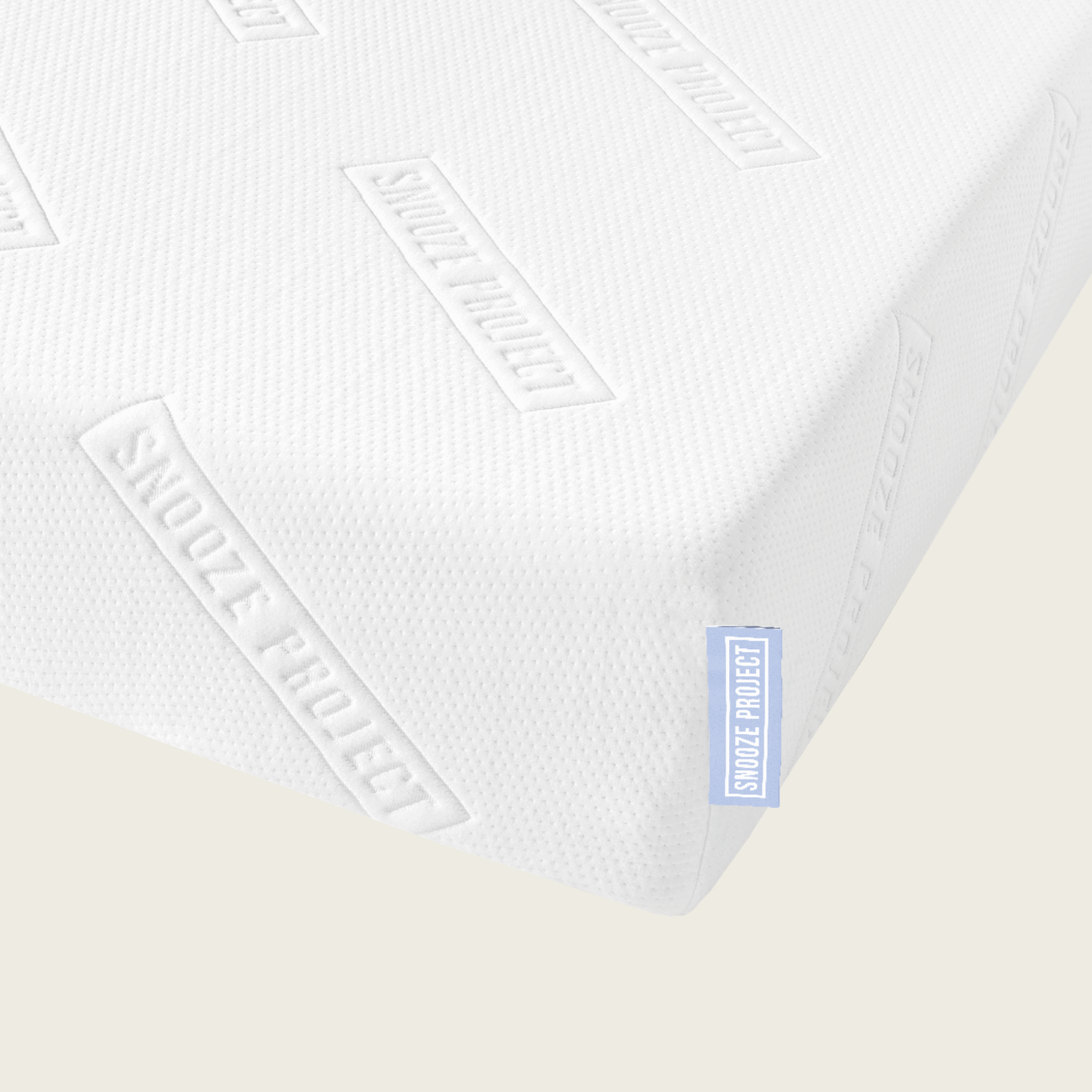 matratze-allgemein-2 Eine Nahaufnahme der Familienbett Matratze zeigt die weiße, strukturierte Oberfläche mit der durchgehenden Prägung "SNOOZE PROJECT". Am Rand ist ein kleines blaues Schildchen mit demselben Text angebracht - ideal für jedes Familienbett.