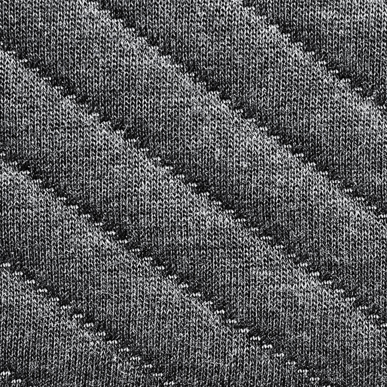Nahaufnahme eines grauen Strickstoffs mit diagonalen Rippenmustern, die ein strukturiertes und gestreiftes Aussehen erzeugen. Das Garn erscheint dick und weich, mit abwechselnd erhabenen und flachen Reihen.