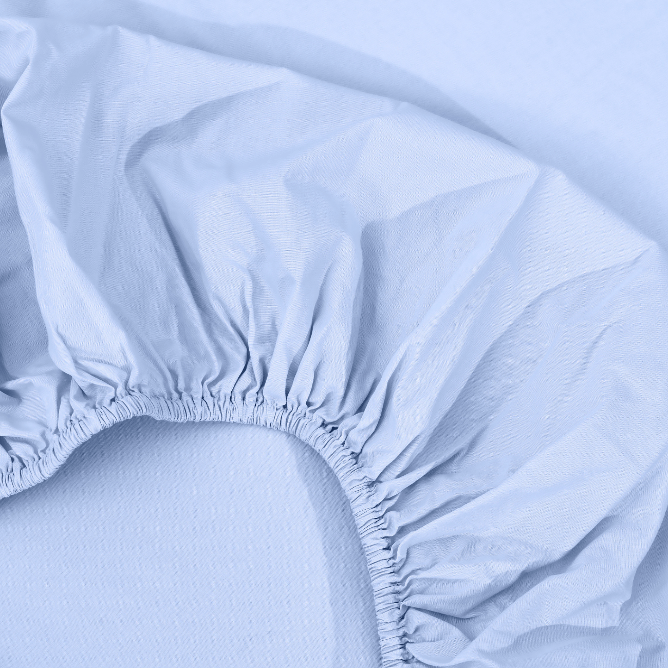 spannbettlaken nach maß hellblau 2 Eine Nahaufnahme eines hellblauen Spannbettlakens mit elastischen Rändern, das auf einer passenden blauen Fläche ausgebreitet ist.