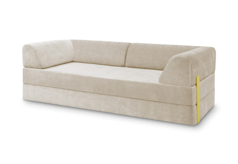 Ein modernes, hellbeige gepolstertes Schlafsofa mit niedriger Rückenlehne und einer einzelnen Armlehne auf der linken Seite, mit einem markanten gelben Akzent an der rechten vorderen Ecke.