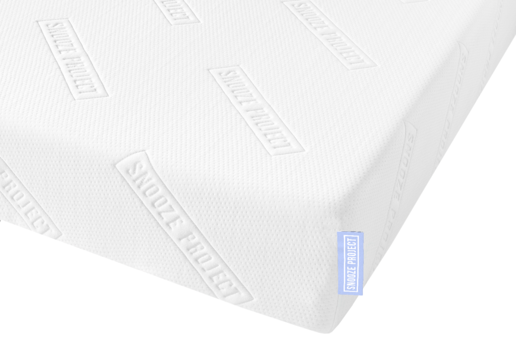 Nahaufnahme einer weißen Matratze mit strukturiertem Bezug und geprägten SNOOZE PROJECT-Logos sowie einem kleinen blauen Stoffanhänger mit der Aufschrift SNOOZE PROJECT-perfekt für deine individuelle Erlebniswelt dank Matratzen nach Maß mit unserem Konfigurator.