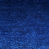 Nahaufnahme einer strukturierten blauen Oberfläche mit leicht rauem, gesprenkeltem Aussehen, das an lackiertes oder beschichtetes Metall erinnert. Die Farbe variiert in verschiedenen Blautönen, wodurch ein visuell reiches Muster entsteht.