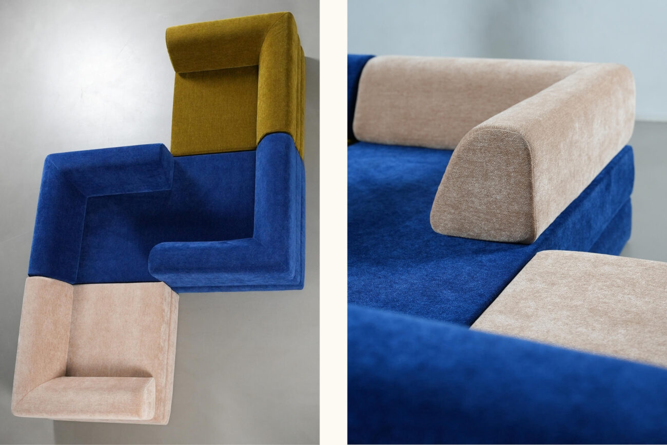 Geometrisches modulares Sofa mit Teilen, die mit senfgelbem, marineblauem und beigem Stoff bezogen und L-förmig angeordnet sind. Die Nahaufnahme zeigt den strukturierten Stoff des Sofas und den kräftigen Farbkontrast.