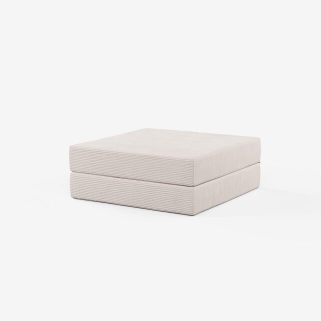 Ein moderner, minimalistischer, hellbeiger, quadratischer Hocker mit subtilen horizontalen, strukturierten Linien vor einem schlichten weißen Hintergrund.