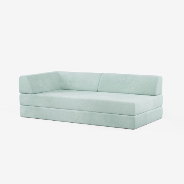 Ein modernes, hellblau gepolstertes Sofa mit niedriger Rückenlehne und Armlehne auf der linken Seite, vor einem schlichten weißen Hintergrund.