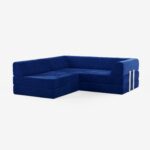 Ein modernes L-förmiges Sektionssofa mit hellblauem Stoffbezug, niedriger Rückenlehne und klaren, minimalistischen Linien vor einem schlichten weißen Hintergrund.